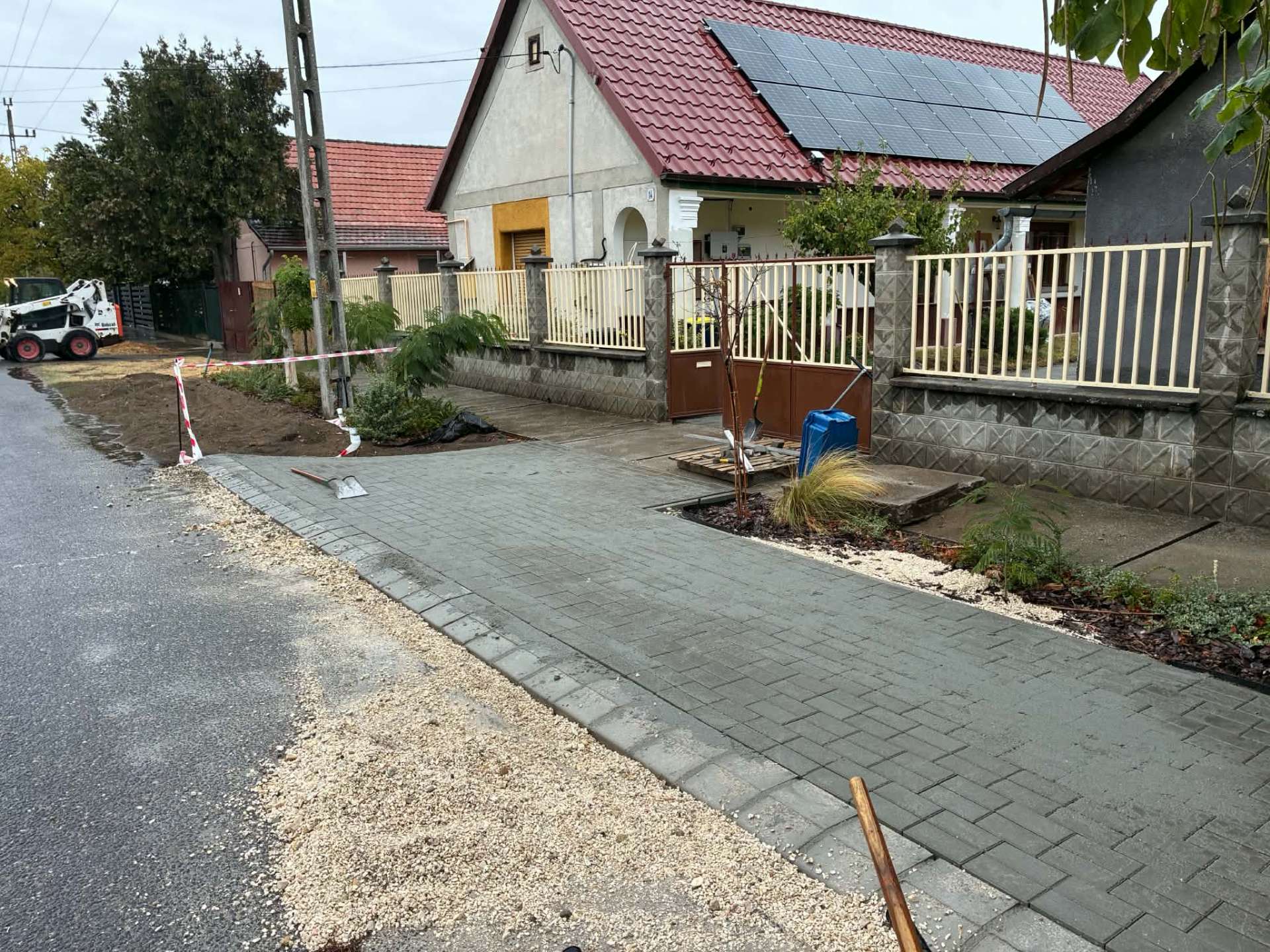 Térkövezett kocsibeálló az utca felől